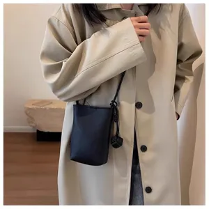 Vue détaillée du mini sac bandoulière noir en cuir PU pour femme avec nœud décoratif.