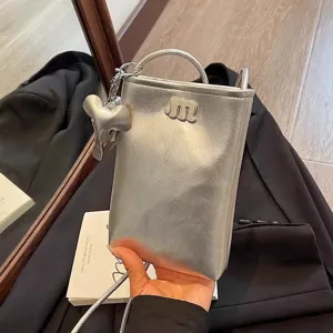 Metallic silver mini phone bag for women with cute elephant charm, stylish crossbody shoulder bag.
