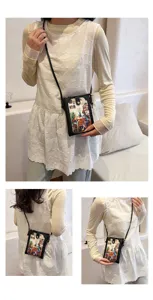 Detailed view of women's black crossbody phone bag with artistic illustration print strap.