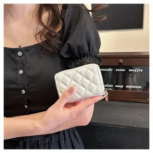Close-up detail shot of a white quilted card holder wallet held by hand, showing fine texture.
