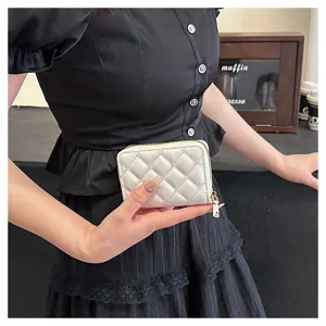Detailed view of the white quilted zip card wallet with accordion slots and gold hardware.