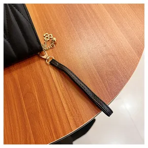 Black quilted long wallet for women with wrist strap chic clutch purse and cute clover charm detail