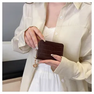 Women's brown crocodile pattern card holder wallet with zipper and cute metal pendant detail.