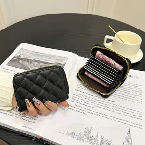 Black quilted leather card holder with zip closure and accordion card slots for women.