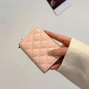 Pink quilted mini card holder for women, compact accordion coin purse with secure zipper closure.