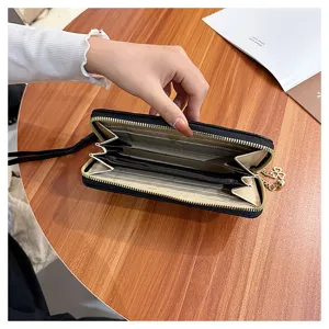 Black quilted long wallet for women with zipper closure, multiple card slots and metal charm.