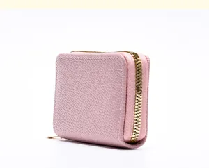 Détail de porte-carte en cuir texturé rose, portefeuille compact à fermeture éclair.