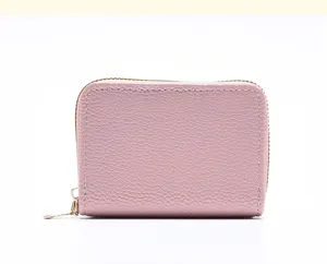 Vue détaillée du porte-cartes minimaliste rose à fermeture éclair en cuir texturé.