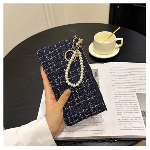 Detailed view of women short tweed woven wallet with pearl keychain and zipper coin pocket clutch.