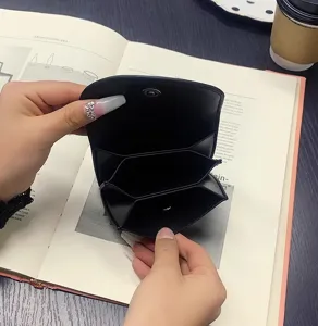 Interior detail view of black PU leather card holder with multiple slots and snap closure.