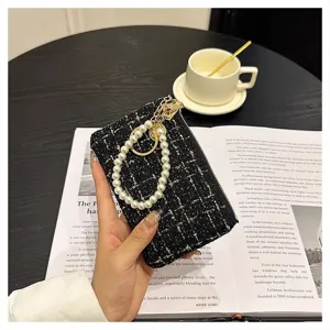 Detailed view of women tweed card holder with pearl chain, elegant black fabric design.