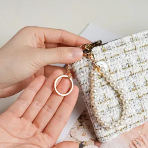 Chic tweed short wallet with pearl wrist strap and gold keychain, perfect compact card holder.