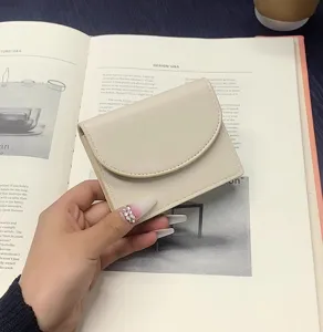 Detailed view of a minimalist beige PU leather short wallet, compact and portable card holder.