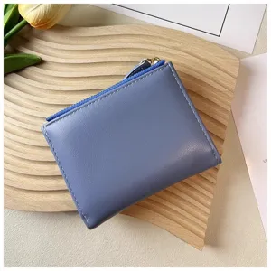 Blue compact leather wallet with zipper and multiple card slots for women daily use.