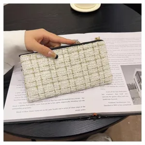 Detail view of a chic white tweed woven zip coin purse with delicate golden metallic threads.