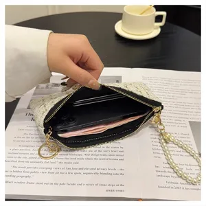 Detail view of woven tweed coin purse with pearl strap, zipper closure and card holder interior.