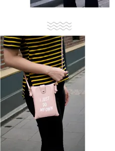 Close-up detail of a trendy pink crossbody phone bag worn outdoors, compact daily accessory.