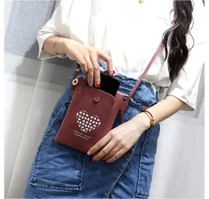 Small crossbody phone bag for women, cute mini PU leather shoulder bag with heart pattern.