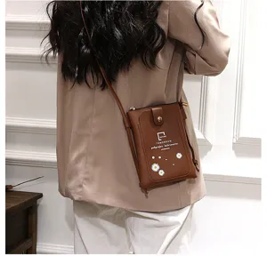 Brown mini leather phone crossbody bag detail, cute daisy print and shoulder strap design.