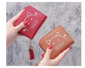 Detailed view of women short zipper wallet with cute cat ears print, tassel pendant, red and brown.
