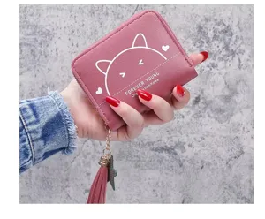 Pink short wallet with cute cat print and tassel pendant, stylish and compact zipper design.