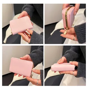 Detailaufnahme der rosa Mini-Kartenbörse mit Reißverschluss und süßem Katzenmuster sowie Goldbeschlägen.