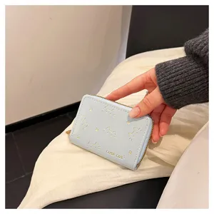 Nahaufnahme einer hellblauen Mini-Reißverschluss-Kartenbrieftasche mit niedlichen Katzen.