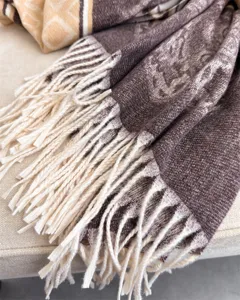 Close up view of brown cashmere feel winter tassel scarf showing soft woven luxury texture.
