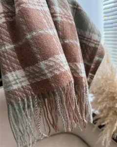 Close up detail of cozy autumn winter plaid fringe scarf shawl warm soft cozy vintage style.