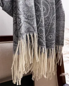 Detailed view of a grey paisley pattern winter tassel scarf, cozy and stylish cashmere feel.
