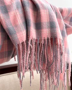 Close-up view of pink and grey plaid cashmere imitation scarf with fringe details.