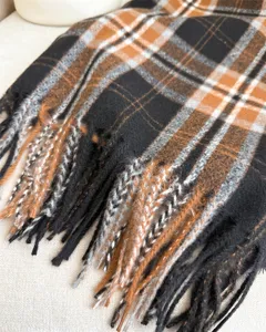 Dettaglio primo piano della classica sciarpa con frange a quadri retro, morbida e unisex.