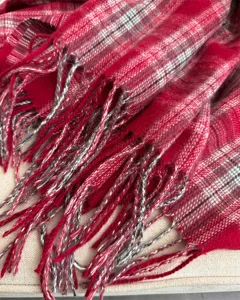 Close-up detailed view of the red plaid winter scarf showing soft tassel texture.
