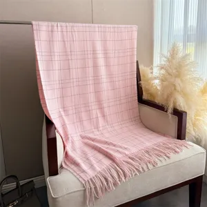 Détail de l'écharpe imitation cachemire à carreaux roses avec texture douce et franges