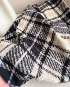 Detailed close-up showing soft loop yarn texture and classic winter plaid pattern.
