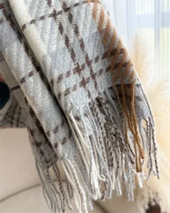 Close-up detail of soft imitation cashmere plaid scarf with stylish fringe trim.