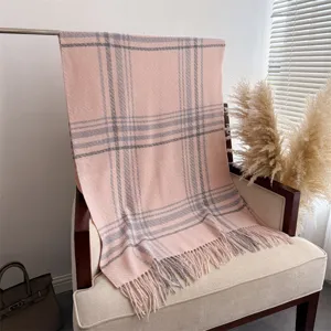 Pink plaid tassel scarf draped on a chair, cozy winter knitted shawl for daily commuting.