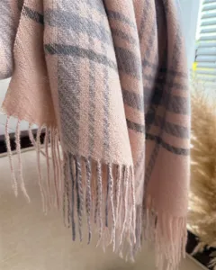 Detail view of a cozy pink and grey plaid winter tassel scarf for stylish daily wear.