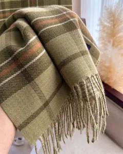 Close up of cozy autumn winter plaid fringed scarf, soft cashmere-like texture, elegant look.