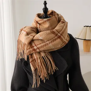 Closeup view of cozy plaid tassel scarf in camel and brown, perfect for autumn and winter.