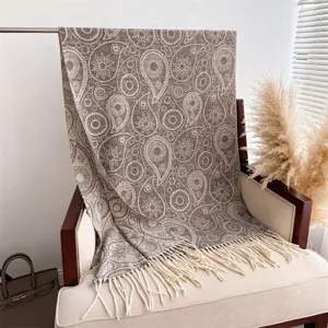 Close-up view of a cozy brown paisley patterned cashmere-feel shawl with elegant fringe details.