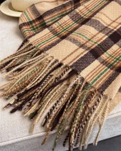 Close-up detail of cozy plaid fringe scarf soft textured winter scarf accessory brown green