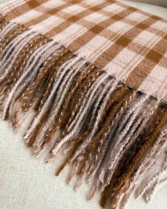 Close-up detail of vintage brown and white plaid cashmere-feel scarf with fringe edges.