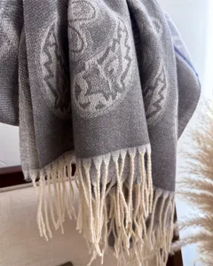 Detailed view of a soft grey cashmere-feel fringed scarf, perfect for autumn and winter warmth.