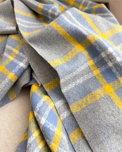 Primo piano di una sciarpa scialle invernale classica a quadri grigio blu e giallo effetto cashmere.