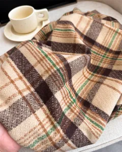 Cozy plaid cashmere-feel scarf detail showcasing soft fabric texture, warm autumn winter style.