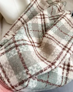 Close-up detail shot of the soft textured imitation cashmere plaid scarf in green and brown.
