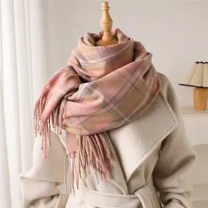 Detailed shot of pink plaid imitation cashmere scarf with fringe, soft and warm winter wear.