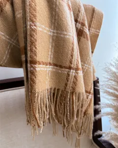 Detailed view of cozy autumn winter plaid fringe scarf shawl soft boucle fabric warm accessory