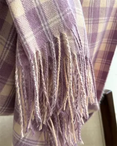 Detailed view of a stylish retro plaid cashmere-feel scarf showing soft tassels and texture.